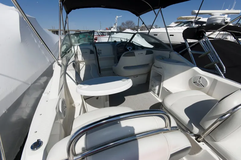 Slide: The Image of Interior of a 2006 Maxum 2600 SE boat, white seating and helm. - 33