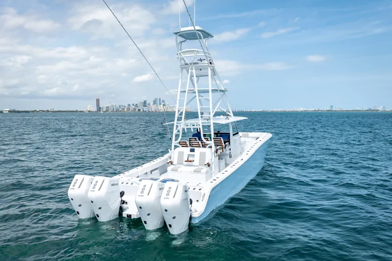 Slide: The Image of 2025 Freeman 43 boat with four engines on open water, city skyline in background. - 23