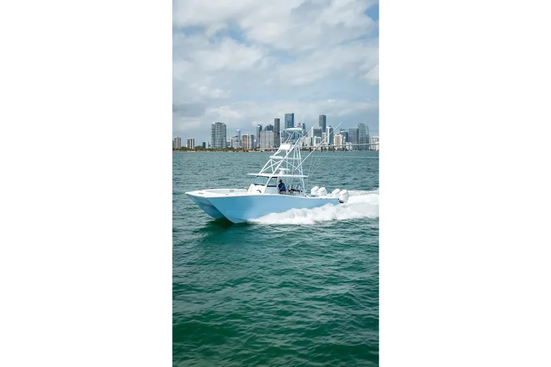 Slide: The Image of 2025 Freeman 43 boat cruising on water with city skyline in background. - 49
