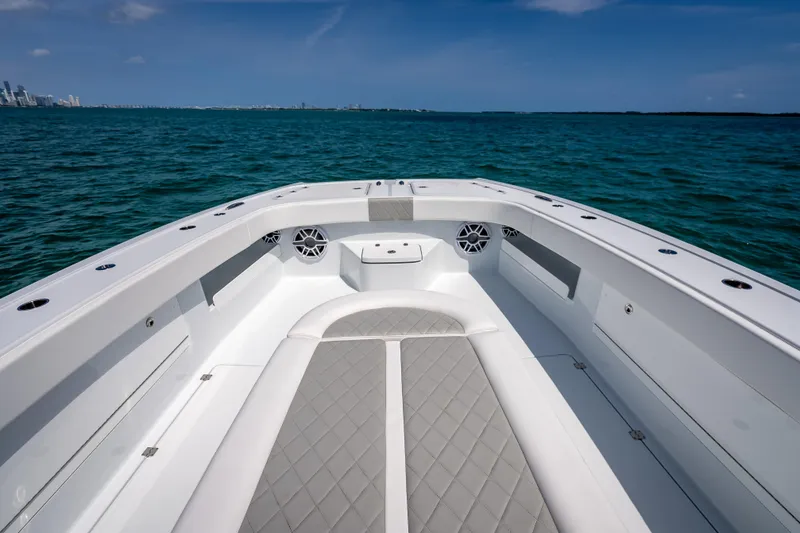 Slide: The Image of 2025 Freeman 43 boat interior with cushioned seating, on open water under clear skies. - 57