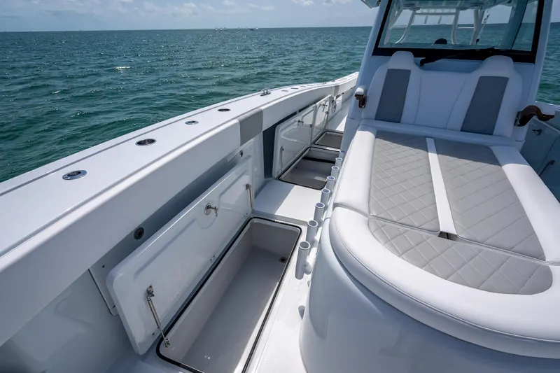 Slide: The Image of 2025 Freeman 43 boat interior with open storage compartments and cushioned seating on the ocean. - 68