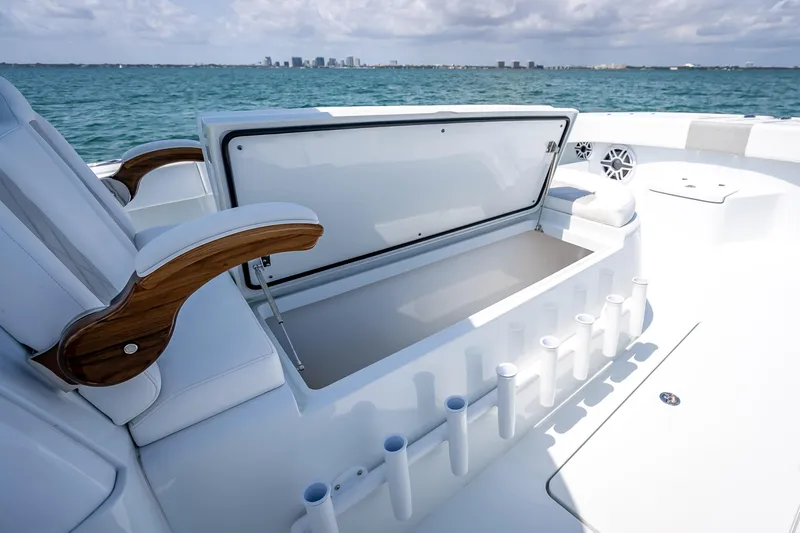 Slide: The Image of 2025 Freeman 43 boat interior with open storage compartment and rod holders, ocean view. - 76