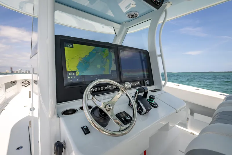 Slide: The Image of Modern Freeman 43 boat dashboard with navigation screens, steering wheel, and ocean view, 2025 model. - 86