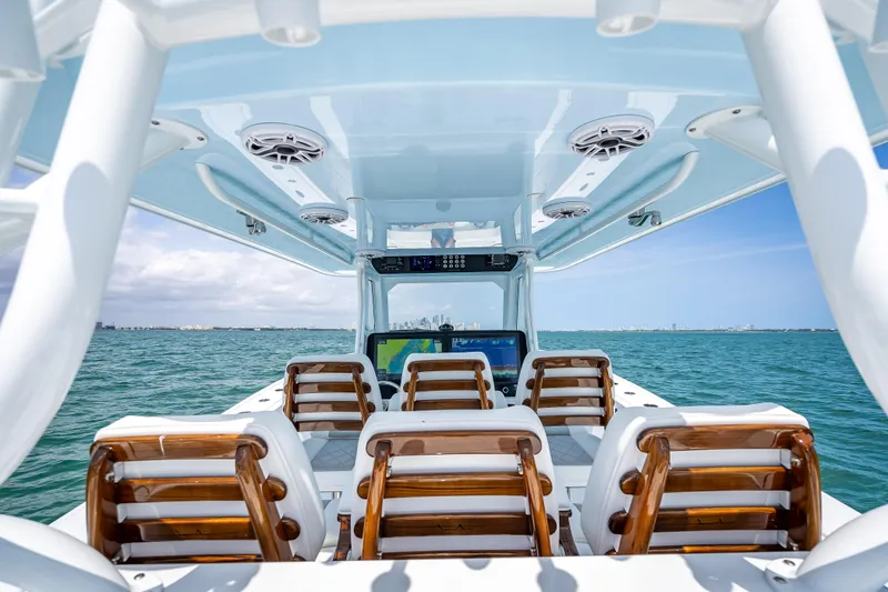 Slide: The Image of 2025 Freeman 43 boat interior with wooden seats, ocean view, and clear blue sky. - 92