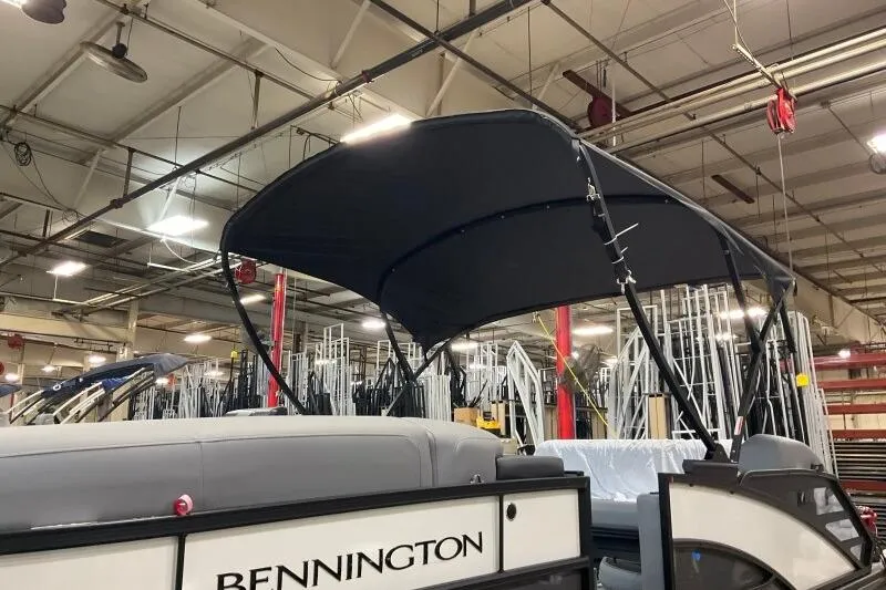 Slide: The Image of 2026 Bennington 23 SSBSF pontoon boat in a factory setting with canopy. - 18