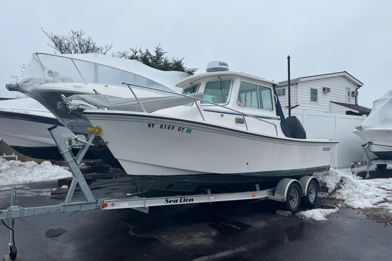 Slide: The Image of 2023 Parker 2120 Sport Cabin boat on trailer in snowy setting. - 14