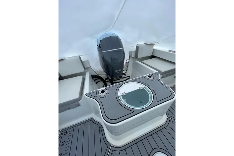 Slide: The Image of 2023 Parker 2120 Sport Cabin boat interior with engine and seating area. - 16