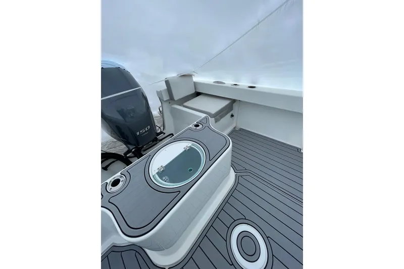 Slide: The Image of 2023 Parker 2120 Sport Cabin boat interior with motor and seating area. - 17