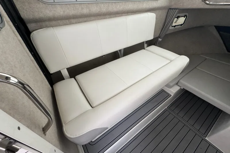 Slide: The Image of 2023 Parker 2120 Sport Cabin interior with white cushioned seating and gray flooring. - 6