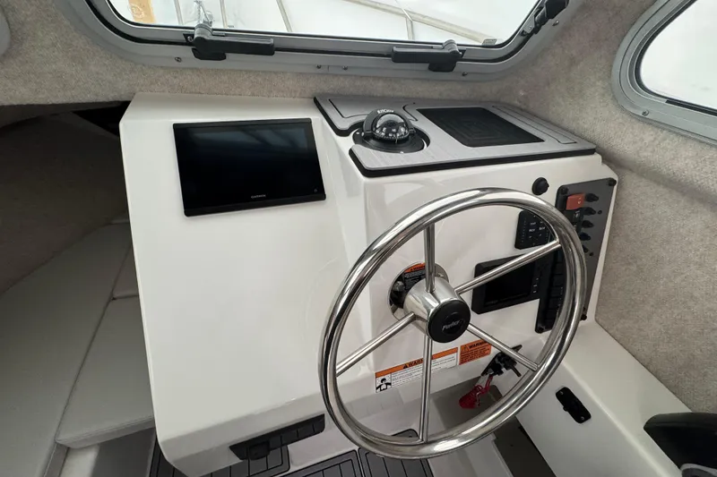 Slide: The Image of 2023 Parker 2120 Sport Cabin helm with steering wheel and navigation display. - 9