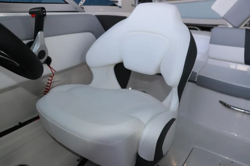 Slide: The Image of 2026 Chaparral 19 SSi OB boat interior with white captain's seat and steering controls. - 23