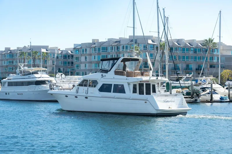 Slide: The Image of 1996 Navigator 5300 Classic yacht cruising in marina with modern buildings in background. - 4