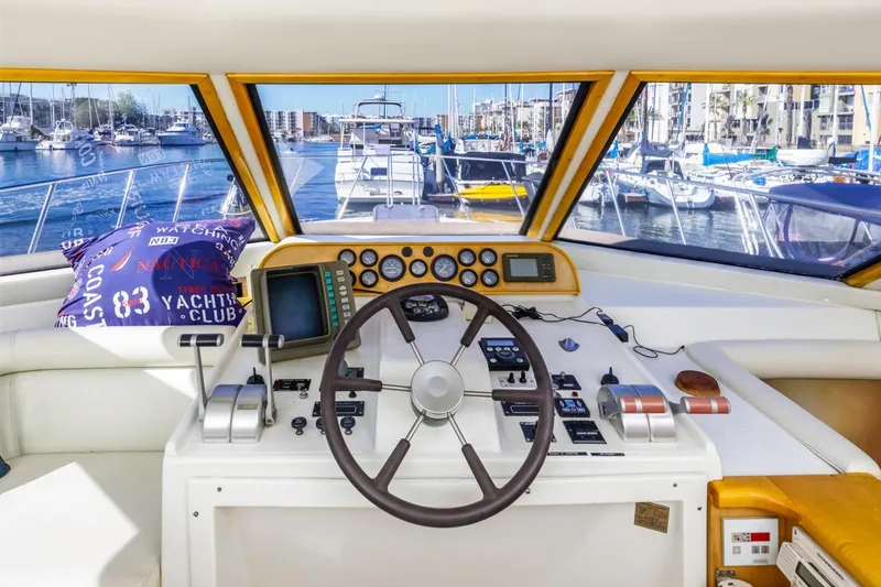 Slide: The Image of Interior view of 1996 Navigator 5300 Classic yacht helm with marina backdrop. - 45