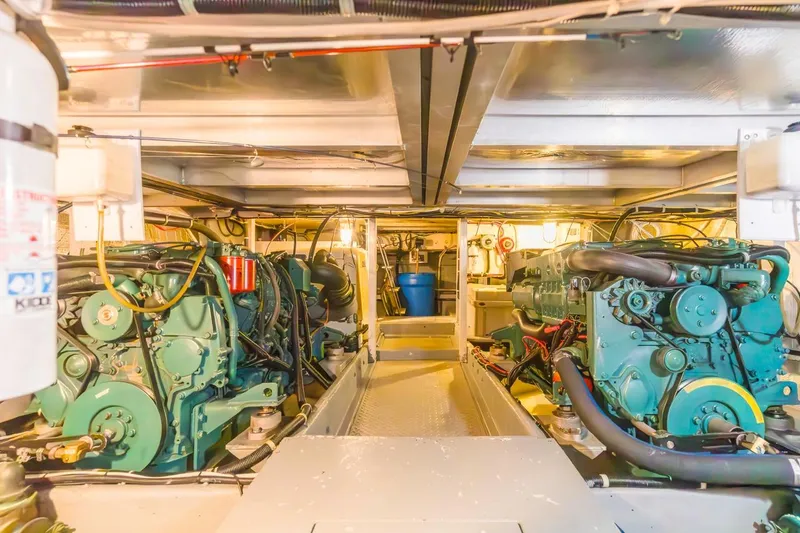 Slide: The Image of Engine room of 1996 Navigator 5300 Classic yacht, featuring dual green engines and mechanical components. - 57