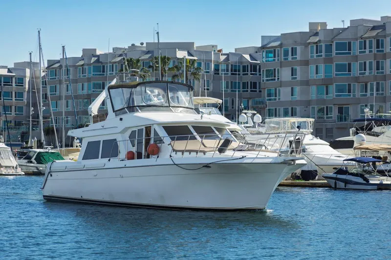 Slide: The Image of 1996 Navigator 5300 Classic yacht docked in marina, surrounded by modern buildings. - 6