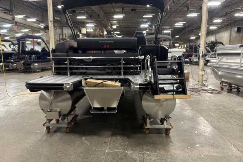 Slide: The Image of 2026 Bennington 23 SSBSF pontoon boat in a factory setting, rear view. - 9