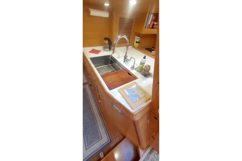Slide: The Image of 2023 Bluewater 56 yacht cockpit with wooden table and ocean view. - 24