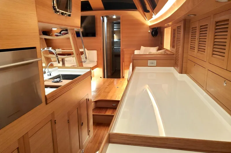 Slide: The Image of 2023 Bluewater 56 yacht cockpit with wooden table, ocean view in background. - 25