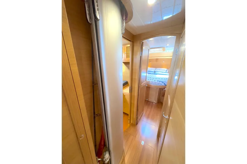 Slide: The Image of Cozy cabin interior of 2023 Bluewater 56 yacht with patterned bedding and wooden storage. - 46