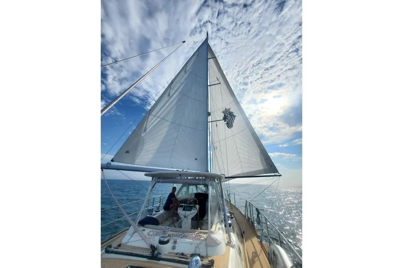 Slide: The Image of 2023 Bluewater 56 yacht sailing on calm waters under clear blue sky. - 7