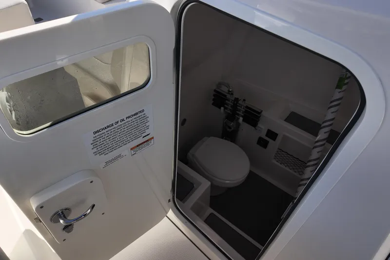 Slide: The Image of 2026 Sailfish 312 CC boat interior with compact marine toilet and storage. - 12