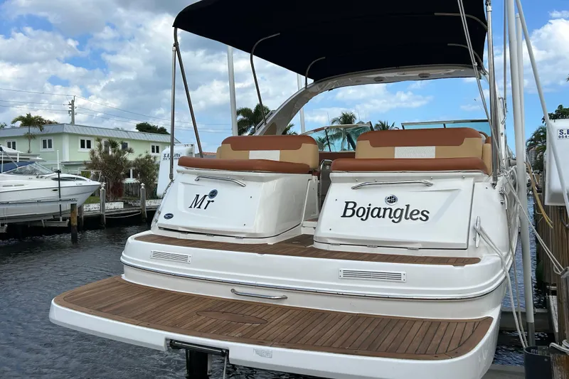Slide: The Image of 2014 Sea Ray 370 Venture boat docked, featuring teak deck and dual seating. - 16