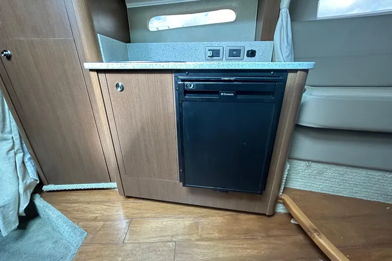 Slide: The Image of 2014 Sea Ray 370 Venture interior with compact kitchenette and Dometic fridge. - 26