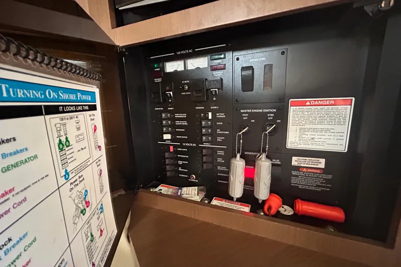 Slide: The Image of Electrical control panel of 2014 Sea Ray 370 Venture boat with safety instructions. - 27