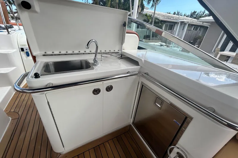 Slide: The Image of 2014 Sea Ray 370 Venture boat kitchenette with sink and storage. - 39
