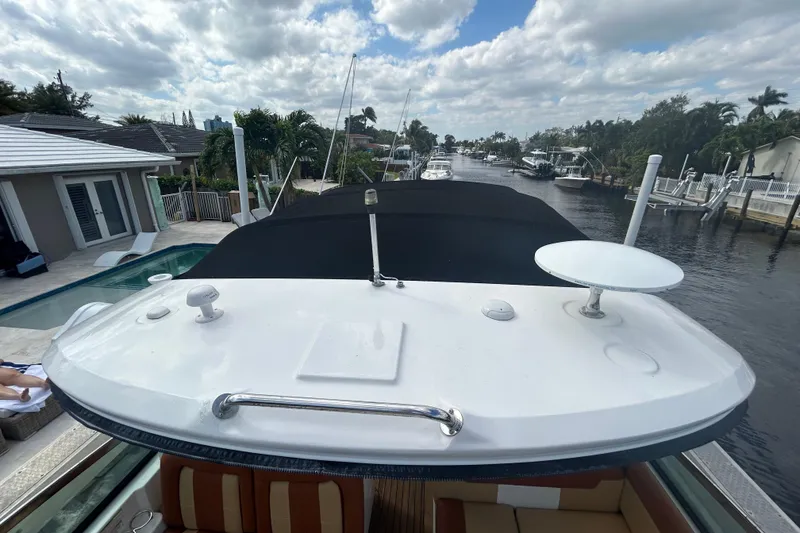 Slide: The Image of 2014 Sea Ray 370 Venture yacht docked by a canal under a cloudy sky. - 41