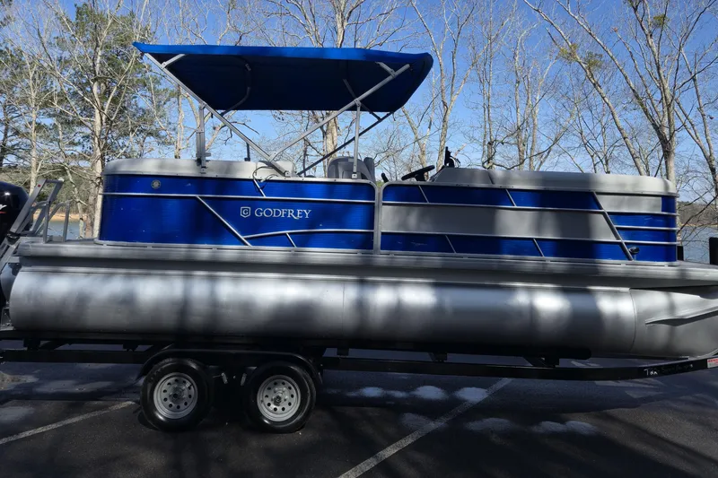 Slide: The Image of 2022 Godfrey Sweetwater 2286 SB pontoon boat on trailer, blue and silver design. - 2