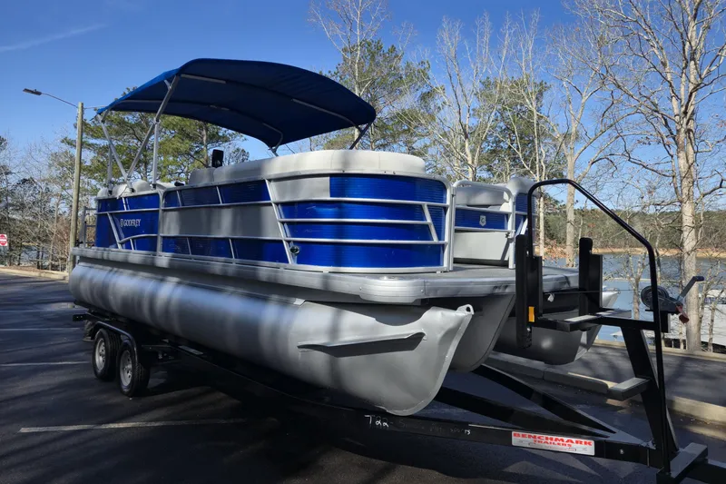 Slide: The Image of 2022 Godfrey Sweetwater 2286 SB pontoon boat on trailer, parked near a lake. - 6