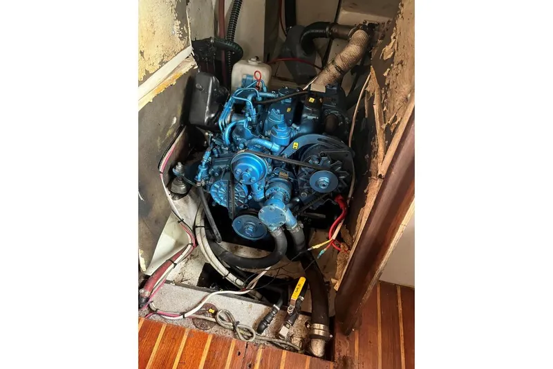 Slide: The Image of 1979 Downeaster 38 engine compartment with blue marine engine and wiring. - 17
