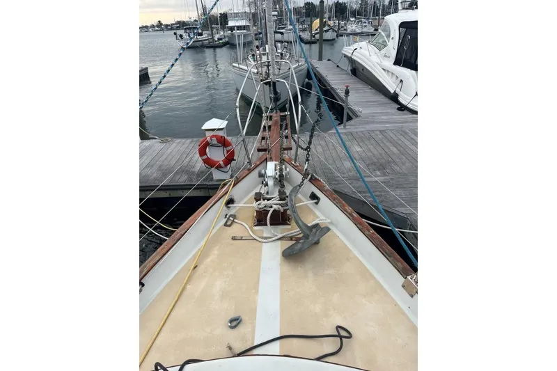 Slide: The Image of 1979 Downeaster 38 sailboat docked at marina, featuring anchor and lifebuoy. - 4