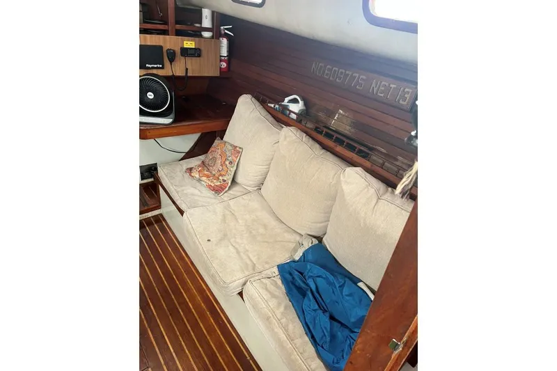 Slide: The Image of Cozy interior of 1979 Downeaster 38 sailboat with cushioned seating and wooden accents. - 9