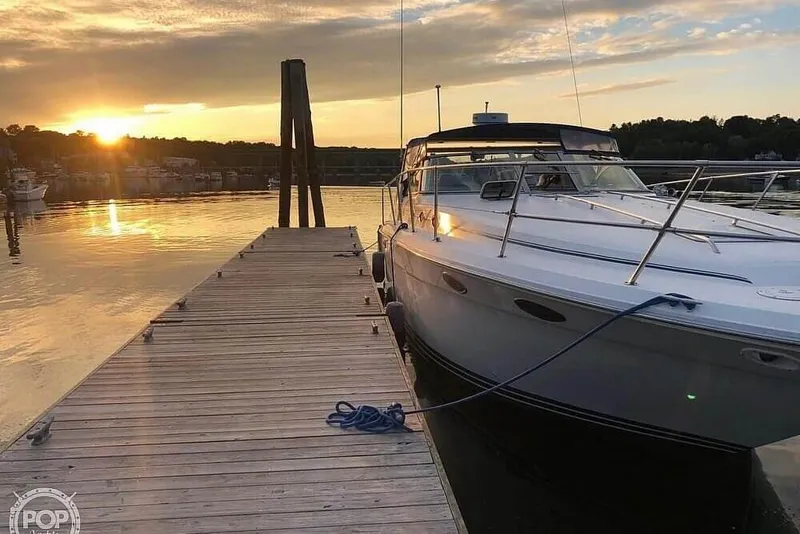 Slide: The Image of 1994 Sea Ray 370 Express Cruiser docked at sunset, serene waterfront view. - 3