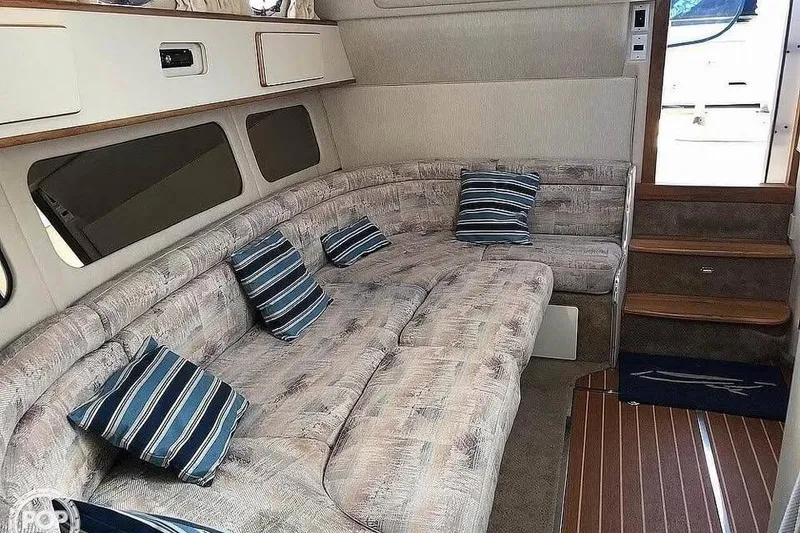 Slide: The Image of 1994 Sea Ray 370 Express Cruiser interior with plush seating and striped cushions. - 4