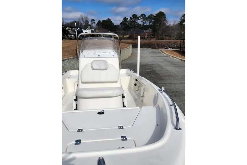 Slide: The Image of 2022 KEYWEST 1720 boat with white seating and console, parked on a driveway. - 3