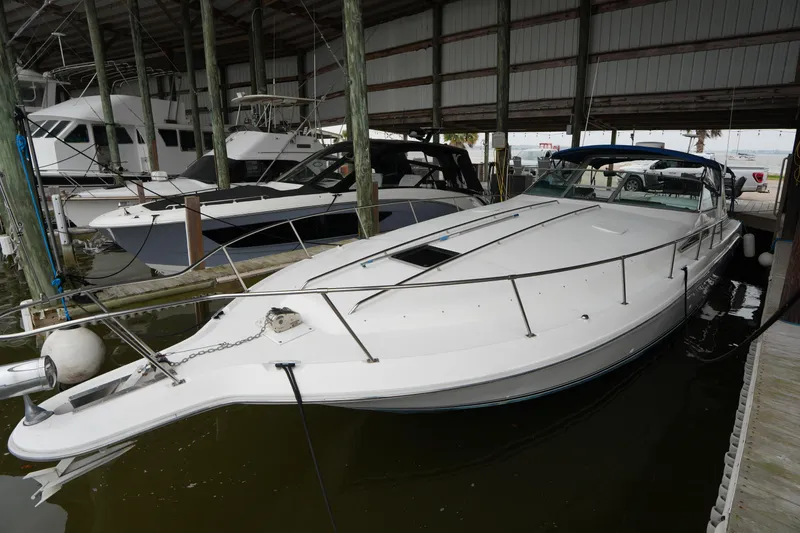 The Image of 1993 Sea Ray 400 Express Cruiser docked in a marina, sheltered under a roof. - 0