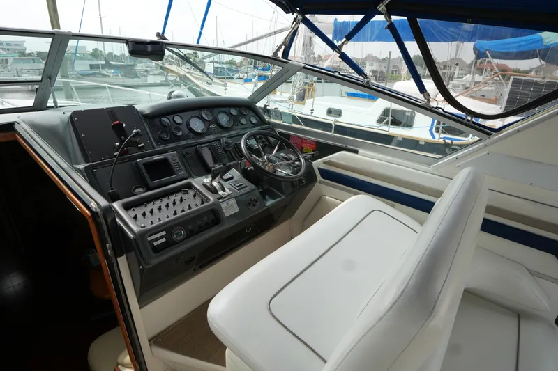 Slide: The Image of Cockpit of 1993 Sea Ray 400 Express Cruiser with steering wheel and control panel. - 12