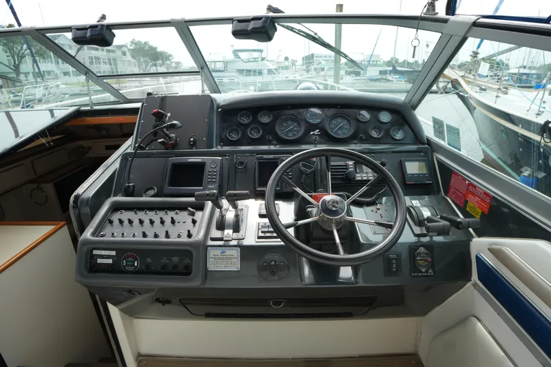 Slide: The Image of Cockpit of 1993 Sea Ray 400 Express Cruiser with steering wheel and control panel. - 13