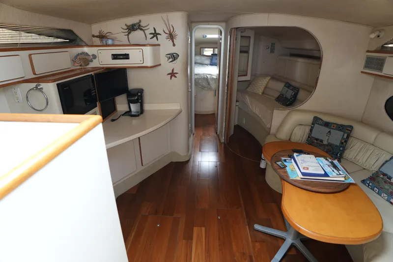Slide: The Image of Interior of a 1993 Sea Ray 400 Express Cruiser with wood flooring and cozy seating. - 15