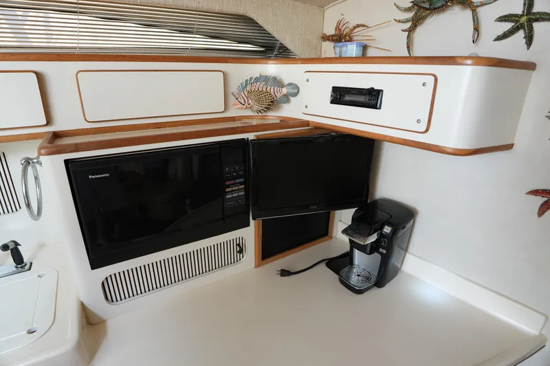 Slide: The Image of 1993 Sea Ray 400 Express Cruiser interior with microwave, TV, and coffee maker. - 18