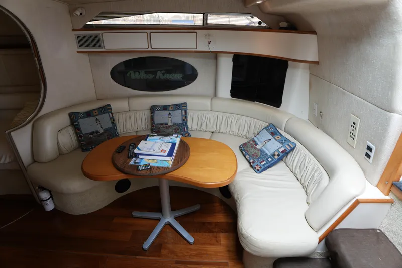 Slide: The Image of Interior of 1993 Sea Ray 400 Express Cruiser with curved seating and wooden table. - 19