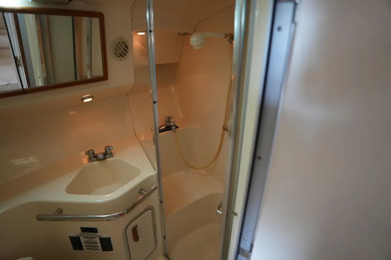 Slide: The Image of 1993 Sea Ray 400 Express Cruiser bathroom with sink, mirror, and shower. - 22