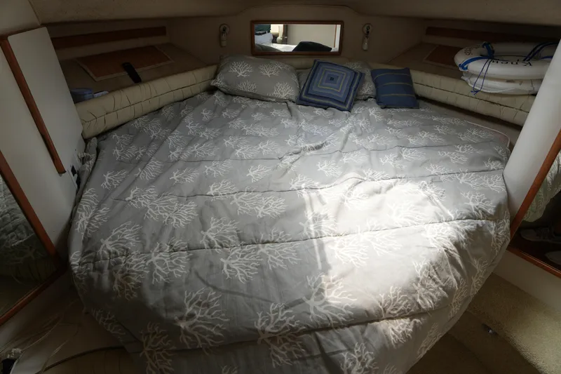 Slide: The Image of Cozy cabin interior of 1993 Sea Ray 400 Express Cruiser with patterned bedding and pillows. - 24