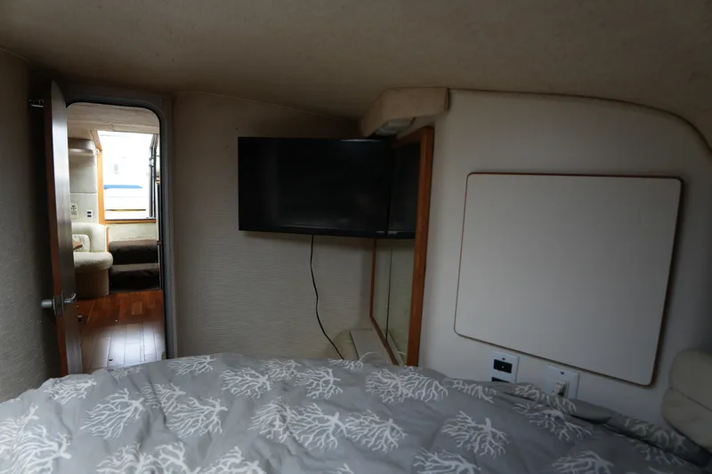 Slide: The Image of Interior cabin of 1993 Sea Ray 400 Express Cruiser with TV and cozy bedding. - 25