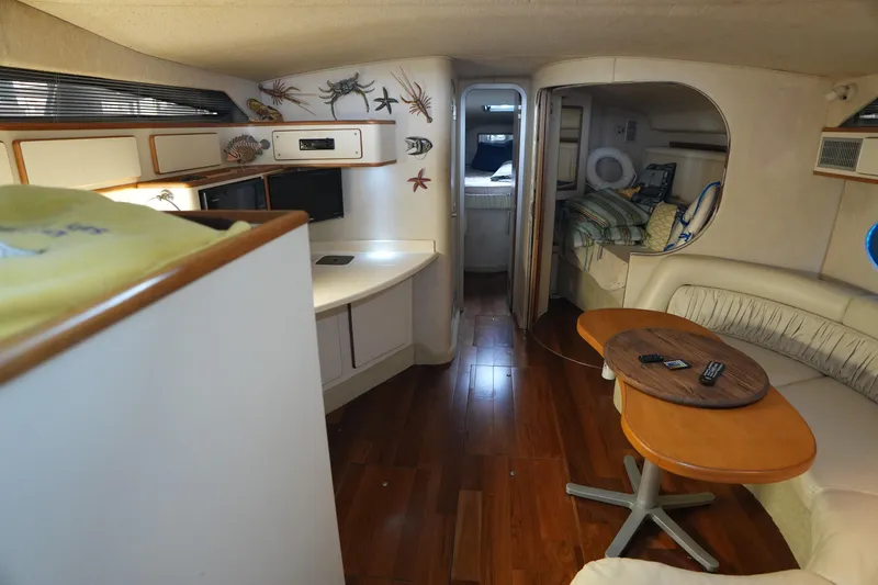 Slide: The Image of Interior of 1993 Sea Ray 400 Express Cruiser with wood flooring and cozy seating area. - 3