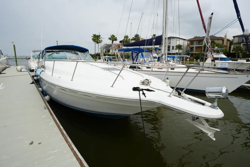 Slide: The Image of 1993 Sea Ray 400 Express Cruiser docked at marina, surrounded by sailboats. - 4
