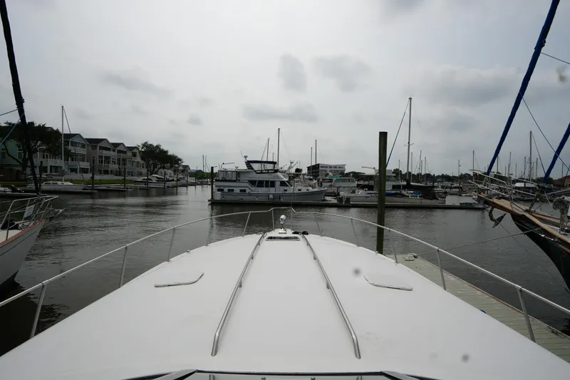 Slide: The Image of 1993 Sea Ray 400 Express Cruiser docked in a marina with surrounding boats. - 6